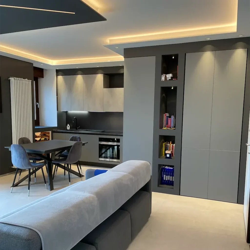 un soggiorno con zona cucina, divano e moderni armadi